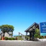 Polmanter sign in front of reception building with bright blue sky and the sea in the background