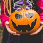 Child holding a pumpkin for October half term